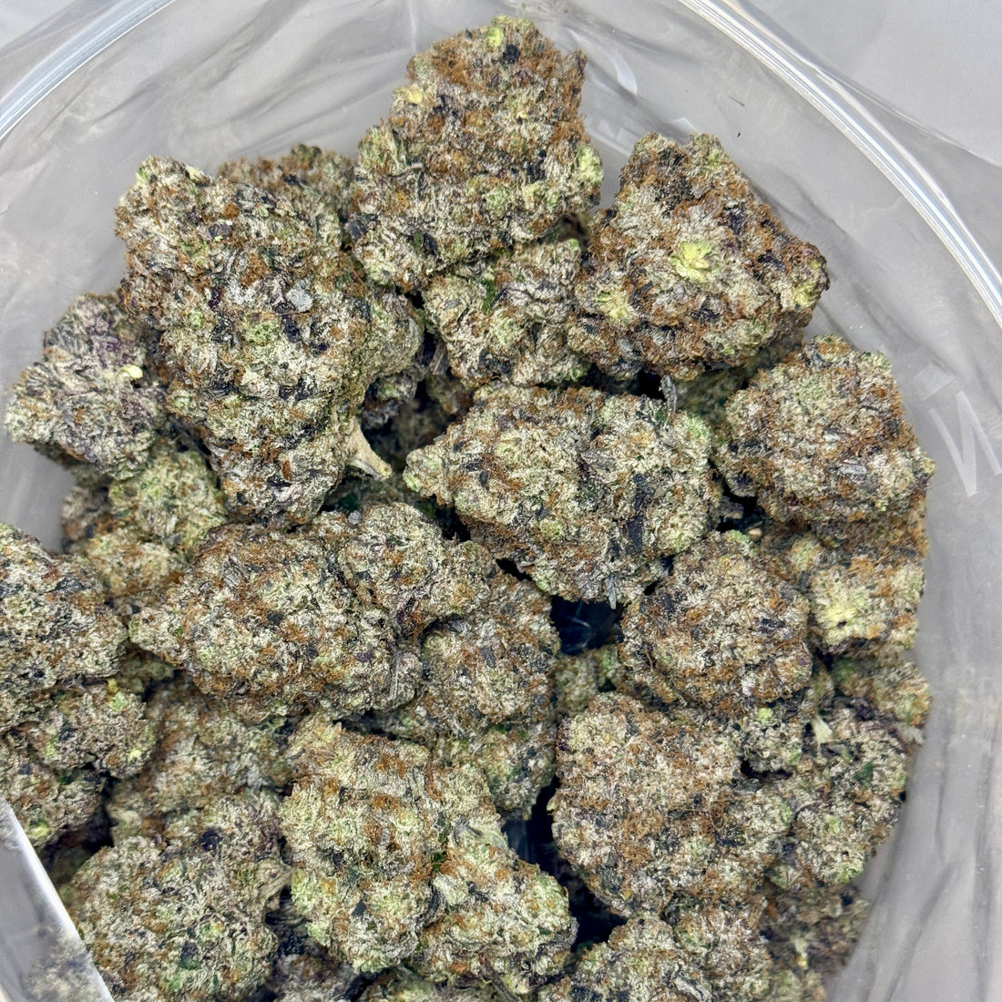 Close-up of Gucci Pink AAAAA Indica – dense purple-green nugs coated in trichomes, Toronto same-day weed delivery